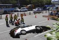 
Petugas pemadam kebakaran Korea Selatan bersiap mengangkat kendaraan yang jatuh ke lubang pembuangan di jalan di Seoul, Korea Selatan, Kamis (29/8/2024). (Seo Dae-yeon/Yonhap via AP)