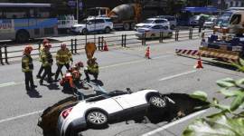
Petugas pemadam kebakaran Korea Selatan bersiap mengangkat kendaraan yang jatuh ke lubang pembuangan di jalan di Seoul, Korea Selatan, Kamis (29/8/2024). (Seo Dae-yeon/Yonhap via AP)