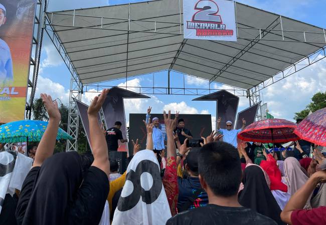 Simulasi pencoblosan contoh surat suara diperagakan Bang Rizal dan Ustadz Rosyadi pada kampanye terbuka perdana di lapangan Abung Limpasu HST, Kamis (26/9/2024). (SuarIndonesia/Ist)