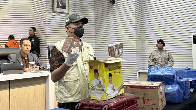 Anggota tim penyidik menunjukkan barang bukti uang dari operasi tangkap tangan KPK Kadis PUPR Kalsel, di gedung KPK, Jakarta, Selasa (8/10/2024) lalu. KPK menyita barang bukti uang Rp12 miliar dan USD500 setelah melakukan operasi tangkap tangan terhadap enam tersangka termasuk Kadis PUPR Kalimantan Selatan Ahmad Solhan dan Kabid Cipta Karya Provinsi Kalimantan Selatan Yulianti Erlynah serta menetapkan Gubernur Kalimantan Selatan Sahbirin Noor sebagai tersangka. (Wardhany Tsa Tsia-VOI)