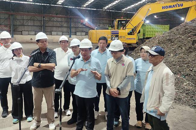 Menteri Lingkungan Hidup (LH)/Badan Pengendalian Lingkungan Hidup (BPLH) Hanif Faisol Nurofiq menjawab pertanyaan wartawan terkait tata kelola sampah di TPST Bantargebang, Bekasi, Jawa Barat, Minggu (27/10/2024) petang. (ANTARA/M Riezko Bima Elko Prasetyo)