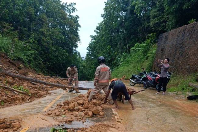 Pihak Kementerian PUPR bersama kepolisian dan warga membersihkan tanah longsor yang sempat menimbulkan akses jalan di Bukit Genting Lanjak, Kecamatan Batang Lupar, Kabupaten Kapuas Hulu, Kalimantan Barat, Jumat (11/10/2024). (ANTARA/HO-Kementerian PUPR)