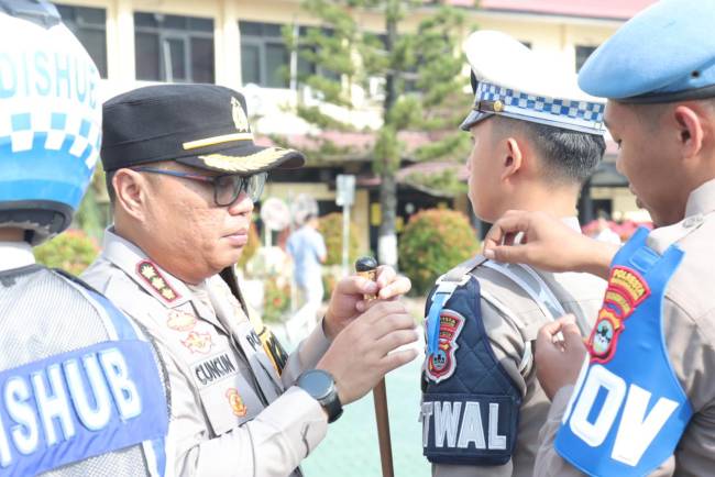 Pemasangan pita warna biru dan putih oleh Kapolresta Banjarmasin Kombes Pol Cuncun Kurniadi pada saat apel gelar pasukan Operasi Patuh Intan 2024, Senin (14/10/2024). (SuarIndonesia/YI)