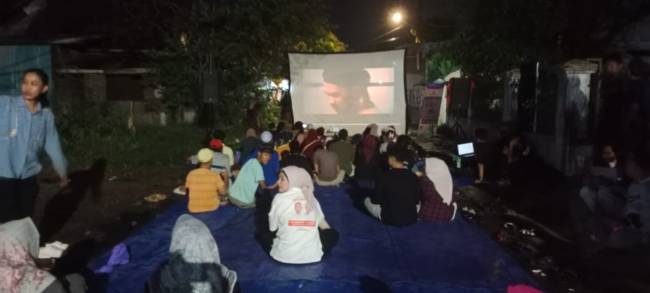 Warga di kawasan Antasan Kecil Barat (Kampung Arab) tepatnya R Coffe Banjarmasin Tengah,  antusias menonton film layar tancap, Sabtu (19/10/2024) malam. (SuarIndonesia/DO)