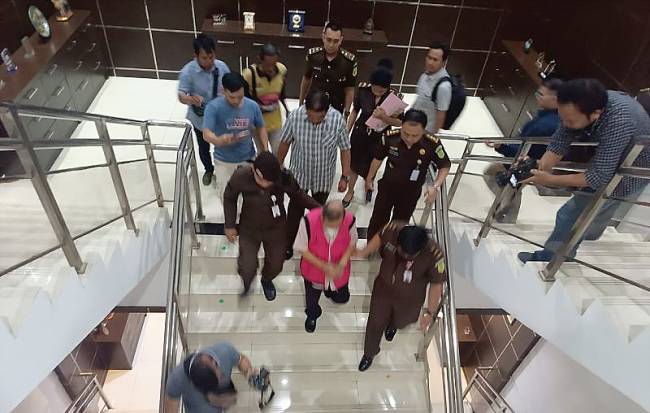 Petugas Kejaksaan Tinggi Pontianak menggiring TAM, anggota DPRD Kalbar yang baru ditetapkan sebagai tersangka kasus Markup pengadaan tanah bangunan bank daerah. (ANTARA/Rendra Oxtora)