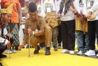 Staf Ahli Bidang Pemerintahan, Hukum dan Politik Provinsi Kalimantan Selatan Adi Santoso mencoba permainan tradisional balogo pada Pekan Kebudayaan Banua di Banjarbaru, Senin (21/10/2024). (ANTARA/HO-Pemprov Kalsel)