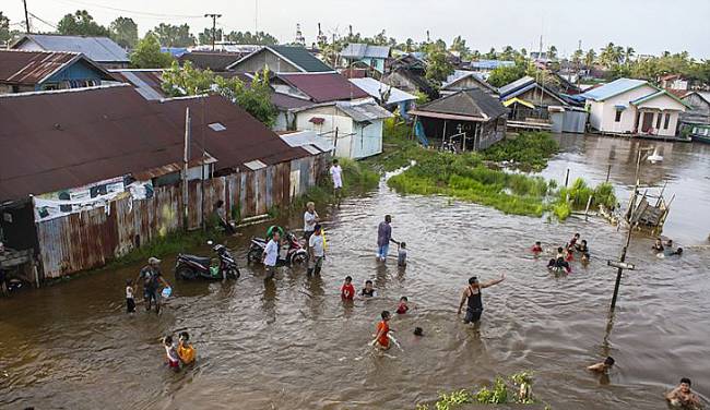 Sejumlah warga bermain air saat air pasang di Banjarmasin, Kalimantan Selatan, Minggu (19/2/2023). (Dok ANTARA/ Bayu Pratama S)
