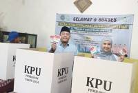Ketua DPRD Banjarbaru Gusti Rizky Sukma Iskandar Putera bersama istri Waode Zaenab memperlihatkan surat suara usai menggunakan hak pilihnya di TPS 17 RT 030 RW 004 Kelurahan Guntung Manggis, Banjarbaru, Provinsi Kalimantan Selatan, Rabu (27/11/2024). (ANTARA/Yose Rizal)
