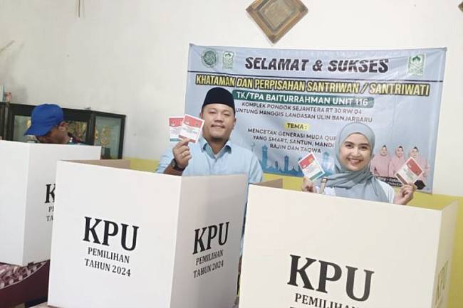 Ketua DPRD Banjarbaru Gusti Rizky Sukma Iskandar Putera bersama istri Waode Zaenab memperlihatkan surat suara usai menggunakan hak pilihnya di TPS 17 RT 030 RW 004 Kelurahan Guntung Manggis, Banjarbaru, Provinsi Kalimantan Selatan, Rabu (27/11/2024). (ANTARA/Yose Rizal)