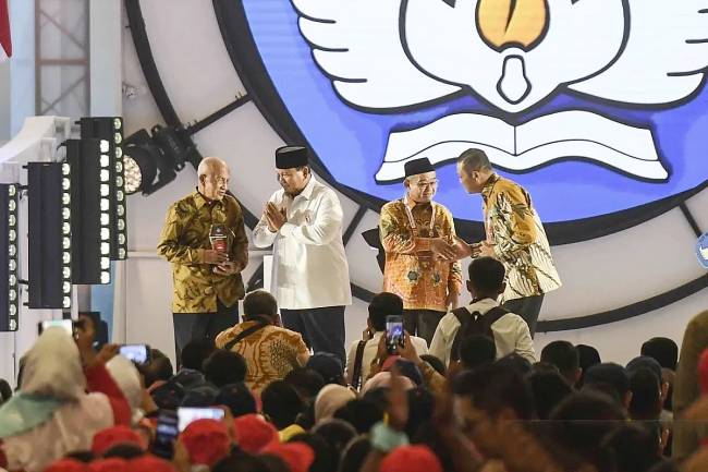Presiden Prabowo Subianto (kedua kiri) didampingi Menteri Pendidikan Dasar dan Menengah Abdul Mu'ti (kedua kanan) memberikan penghargaan kepada Melan Achmad (kiri) dan Kuswanto (kanan) pada puncak peringatan Hari Guru Nasional 2024 di Jakarta International Velodrome, Jakarta, Kamis (28/11/2024). (ANTARA FOTO/Hafidz Mubarak A)