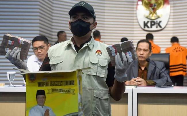 Petugas menunjukkan barang bukti sejumlah uang disaksikan Wakil Ketua KPK Nurul Ghufron (kanan) dan Direktur Penyidikan KPK Brigjen Pol. Asep Guntur Rahayu (kiri) dalam konferensi pers penahanan enam tersangka OTT di Kalimantan Selatan, di Gedung Merah Putih KPK, Jakarta, Selasa (8/10/2024). (ANTARA FOTO/Indrianto Eko Suwarso/foc)