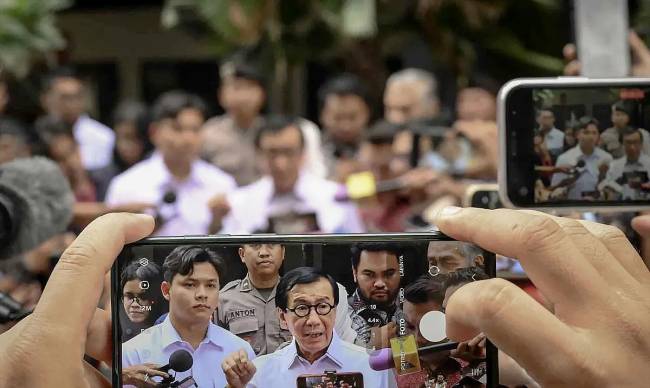 Jurnalis mengambil gambar Menteri Hukum dan HAM periode 2019-2024 Yasonna Laoly (tengah) saat memberikan keterangan kepada media usai menjalani pemeriksaan di Gedung Merah Putih KPK, Jakarta, Rabu (18/12/2024). (Dok: ANTARA FOTO/Muhammad Ramdan)