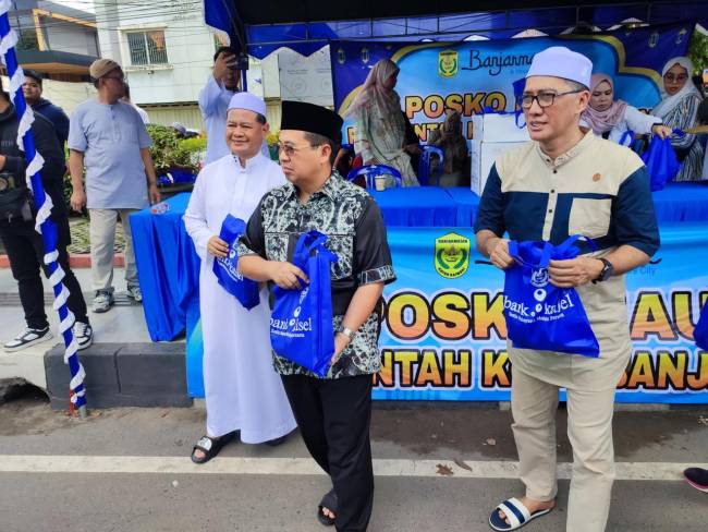 LAYANANAN KONSUMSI - Wali Kota Banjarmasin H Ibnu Sina didampingi Sekretaris Daerah (Sekda) Kota Banjarmasin, Ikhsan Budiman, Dirut Bank Kalsel, Fachrudin, Kepala Cabang Bank Kalsel Suriadi serta kepala SKPD Pemko Bajarmasin saat membaikan konsumsi gratis pada para pengendara roda dua hingga mobil penumpang.