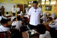 Kepala Kantor Komunikasi Kepresidenan Hasan Nasbi (kedua kanan) berbincang dengan siswa saat meninjau pelaksanaan Program Makan Bergizi Gratis di SDN Kedung Badak 1, Tanah Sareal, Kota Bogor, Jawa Barat, Senin (6/1/2025). (ANTARA FOTO/Arif Firmansyah)
