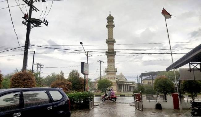 Seorang warga melintas di jalan raya saat hujan mengguyur Kota Palangka Raya, beberapa waktu lalu. (ANTARA/Rendhik Andika)