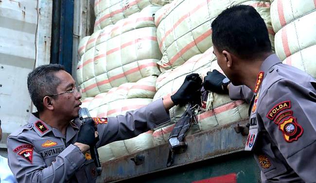 Wakapolda Kalbar Brigjen Pol Roma Hutajulu (kiri) menarik dasi dari dalam ballpress saat memberikan keterangan pers tentang ungkap kasus penggagalan penyelundupan pakaian bekas dari Malaysia di Polda Kalbar, Senin (20/1/2025). (ANTARA/HO-Jessica Helena Wuysang)