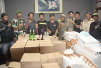 Personel TNI bersama satpol-PP menunjukkan barang bukti hasil pengamanan aksi penyelundupan seribu lebih minuman beralkohol beserta pihak yang mengangkut menggunakan truk ekspedisi di Bima, NTB, Minggu (9/2/2025). (ANTARA/HO-Kodim Bima)
