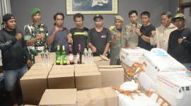 Personel TNI bersama satpol-PP menunjukkan barang bukti hasil pengamanan aksi penyelundupan seribu lebih minuman beralkohol beserta pihak yang mengangkut menggunakan truk ekspedisi di Bima, NTB, Minggu (9/2/2025). (ANTARA/HO-Kodim Bima)
