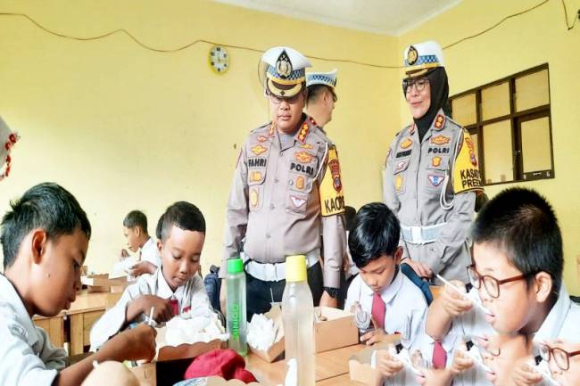 
Direktur Lalu Lintas Polda Kalsel Kombes Pol Fahri Anggia Natua Siregar saat menyapa anak-anak yang asik menyantap makanan bergizi di SDN 3 Landasan Ulin Barat, Kota Banjarbaru, Senin (10/2/2025). (ANTARA/Firman)