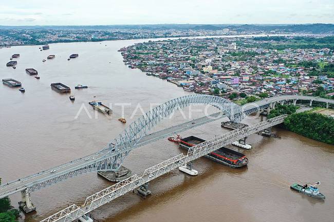 Lalu lintas kapal tongkang yang tampak ramai melintasi kolong Jembatan Mahakam. (Foto: ANTARA/M Risyal H)