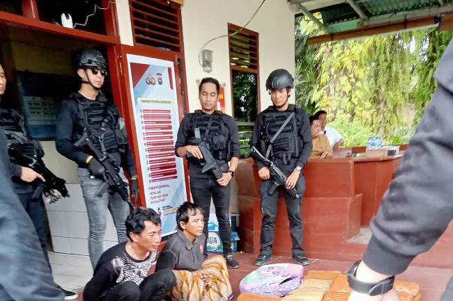 Dua orang pelaku pembawa mobil boks yang berisi narkotika jenis ganja saat diamankan petugas di Kecamatan Kinali, Kabupaten Pasaman Barat, Sumatera Barat, Minggu (16/2/2025). (ANTARA/HO-Polres Pasaman Barat)
