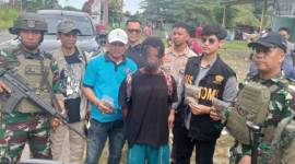 
Tim gabungan TNI-Polri beserta Bea Cukai dan Imigrasi menangkap JK (tengah), warga negara Papua Nugini (PNG), yang membawa 12 paket ganja, di Pos Lintas Batas Negara (PLBN) Skouw, Jayapura, Papua, Minggu (9/2/2025). (ANTARA/HO-Polresta Jayapura Kota)