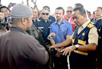 Menteri Energi dan Sumber Daya Mineral (ESDM) Bahlil Lahadalia (kanan) berdialog dengan pembeli Bahan Bakar Minyak (BBM) Pertalite RON 90 dalam kunjungan kerja di SPBU Banjarbaru, Kalimantan Selatan, Rabu (19/3/2025). (Foto: ANTARA/Tumpal A Aritonang)