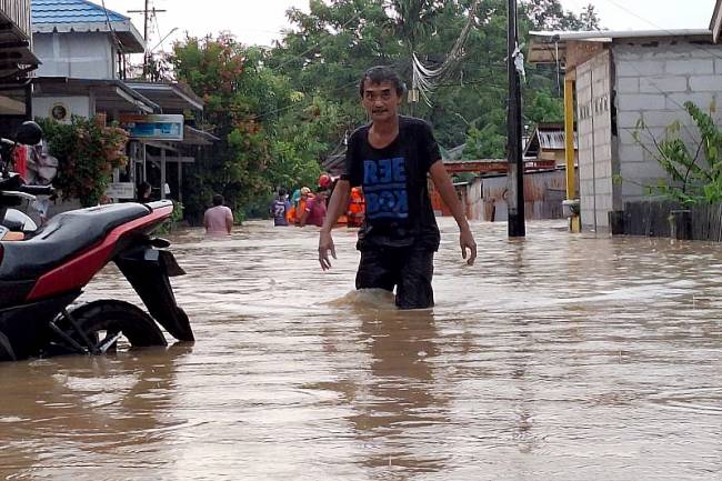 Seorang warga Kota Balikoapan, Provinsi Kalimantan Timur, sedang berusaha keluar dari genangan air di kawasan jalan penegak, Jumat (7/3/2025) (Foto: ANTARA/M Solih J)