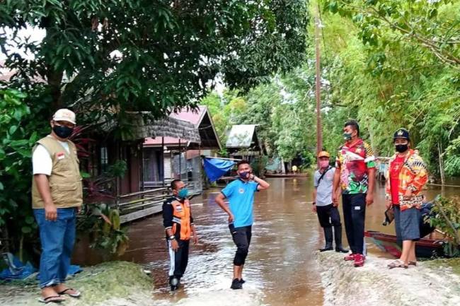 
Sejumlah personel BPBD Palangka Raya bersama pegawai Kelurahan Marang memantau debit air sungai yang meluap ke permukiman warga, Sabtu, (3/4/2021). (Foto: Dokumentasi ANTARA)