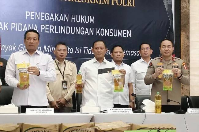Direktur Tindak Pidana Ekonomi Khusus (Dirtipideksus) sekaligus Kepala Satgas Pangan Polri Brigjen Pol Helfi Assegaf (tengah) dengan didampingi Kepala Biro Penerangan Masyarakat (Karopenmas) Divhumas Polri Brigjen Pol Trunoyudo Wisnu Andiko (kanan) dan Inspektur Jenderal Kementerian Pertanian (kiri) Brigjen Pol Kurniawan Affandi menunjukkan barang bukti MinyaKita tak sesuai takaran dalam konferensi pers di Gedung Bareskrim Polri, Jakarta, Selasa (11/3/2025). (Foto: ANTARA/Nadia PR)