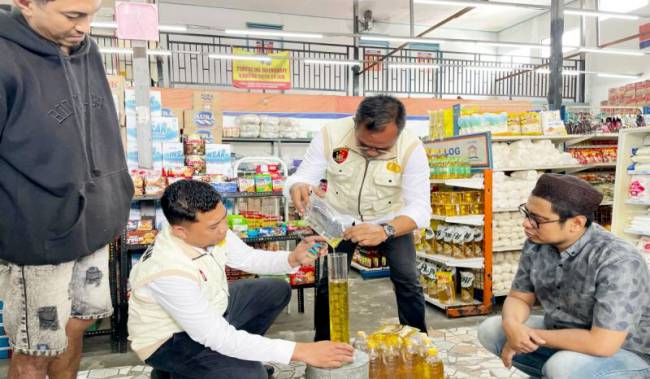 
Satgas Pangan Polda Kalimantan Selatan saat mengecek volume produk MinyaKita isi satu liter di sebuah toko bahan pokok di Banjarmasin. (Foto: ANTARA/Firman)