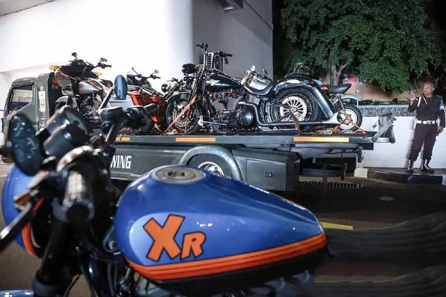 Petugas berjaga di samping mobil towing yang membawa sepeda motor sitaan terkait kasus dugaan suap di PN Jakpus setibanya di Gedung Kejaksaan Agung, Jakarta, Minggu (13/4/2025). (Foto: ANTARA/Dhemas Reviyanto)