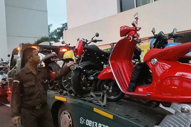 Petugas pengamanan Kejaksaan Agung menghitung jumlah sepeda motor yang disita dalam kasus dugaan suap dan/atau gratifikasi terkait dengan putusan lepas (ontslag) perkara korupsi pemberian fasilitas ekspor crude palm oil (CPO) di Pengadilan Negeri Jakarta Pusat, di Gedung Kartika Kejaksaan Agung, Jakarta, Minggu (13/4/2025). (Foto: ANTARA/Nadia Putri Rahmani)