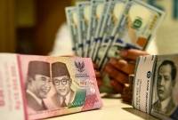 Foto Ilustrasi - Petugas perbankan menunjukan uang pecahan dolar AS dan rupiah. (Foto: ANTARA/M Adimaja)