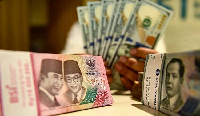 Foto Ilustrasi - Petugas perbankan menunjukan uang pecahan dolar AS dan rupiah. (Foto: ANTARA/M Adimaja)