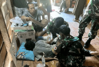 Prajurit 141/AYJP sedang mengobati seorang pendulang yang berhasil menyelamatkan diri hingga ke Pos Korowai, Kabupaten Asmat. (Foto: ANTARA/HO-Satgas Damai Cartenz)
