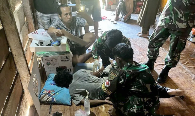 Prajurit 141/AYJP sedang mengobati seorang pendulang yang berhasil menyelamatkan diri hingga ke Pos Korowai, Kabupaten Asmat. (Foto: ANTARA/HO-Satgas Damai Cartenz)
