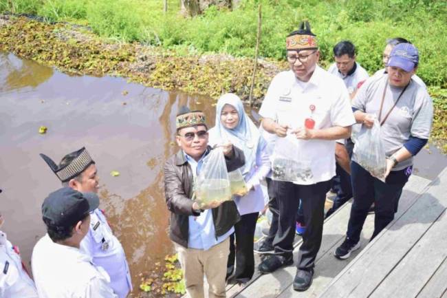 Gubernur Kalimantan Tengah Agustiar Sabran menebar benih ikan Papuyu (Betok) di Danau Tahai, Kelurahan Tumbang Tahai, Kecamatan Bukit Batu, Kota Palangka Raya, Rabu (21/5/2025). (ANTARA/HO-Pemprov Kalteng)