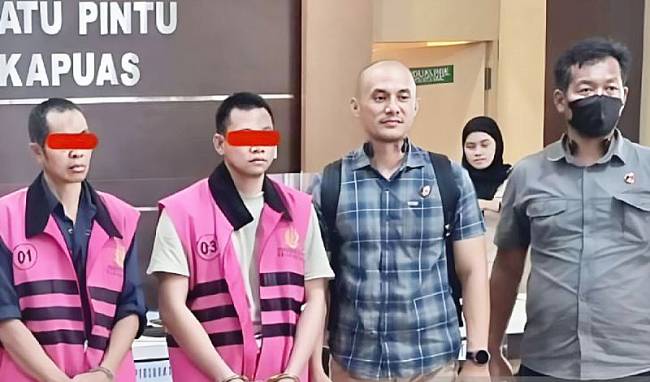 Dua tersangka GB dan MA menggunakan paju tahanan saat diserahkan oleh petugas dari Polres Kapuas, ke Kejaksaan Negeri Kuala Kapuas. (ANTARA/HO-Polres Kapuas)