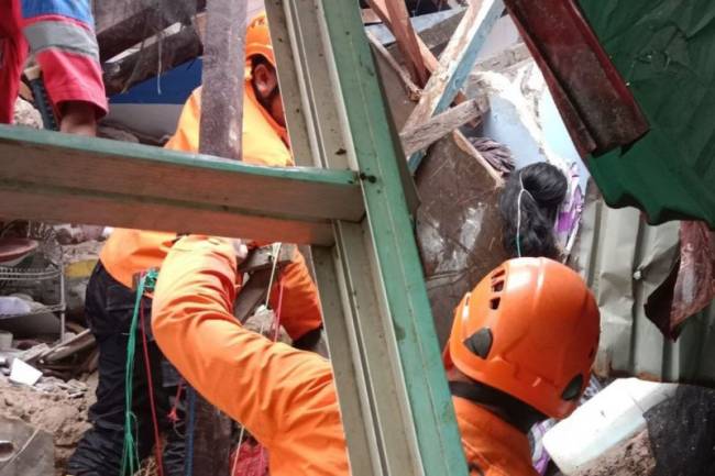 Anggota SAR Pos Samarinda saat mencari korban di reruntuhan rumah akibat tanah longsor di Jalan Gerilya Gang Keluarga, Samarinda. (Antara/HO-SAR Pos Samarinda)