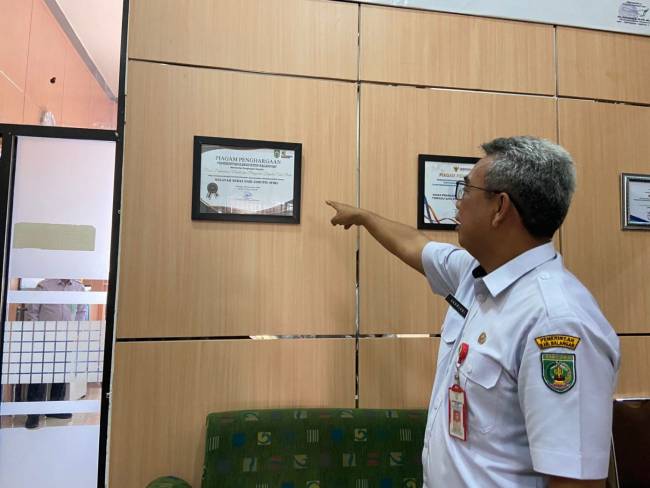 Kepala DPMPTSP Balangan, Akhriani, menunjukkan piagam penghargaan Wilayah Bebas dari Korupsi (WBK). Foto : MC Kab Balangan