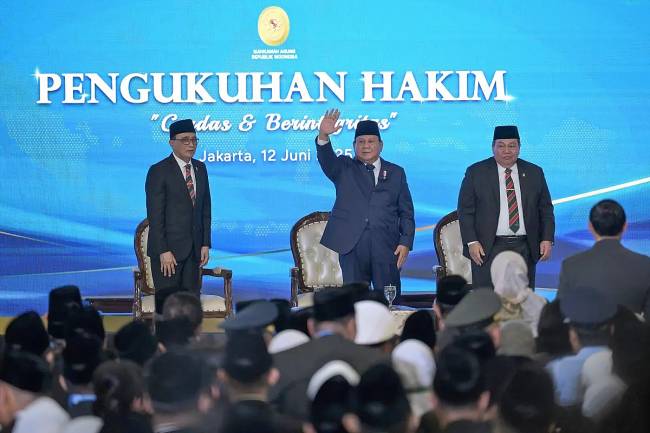 Presiden Prabowo Subianto (tengah) didampingi Ketua Mahkamah Agung (MA) Sunarto (kiri) dan Wakil Ketua Mahkamah Agung bidang non Yudisial Suharto (kanan) melambaikan tangan kepada para hakim baru usai upacara pengukuhan di Gedung MA, Jakarta, Kamis (12/6/2025).(Foto: ANTARA/Aditya P Putra)
