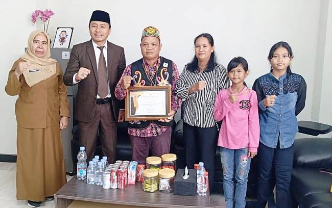 Kepala DPMPD Kaltim Puguh Harjanto (dua dari kiri) bersama Ketua MHA Benuaq Telimuk Elsa Wijaya (ketiga dari kiri). Elsa Wijaya bersama istri dan anaknya saat mengunjungi Kantor DPMPD Kaltim. (Foto: ANTARA/M Ghofar)