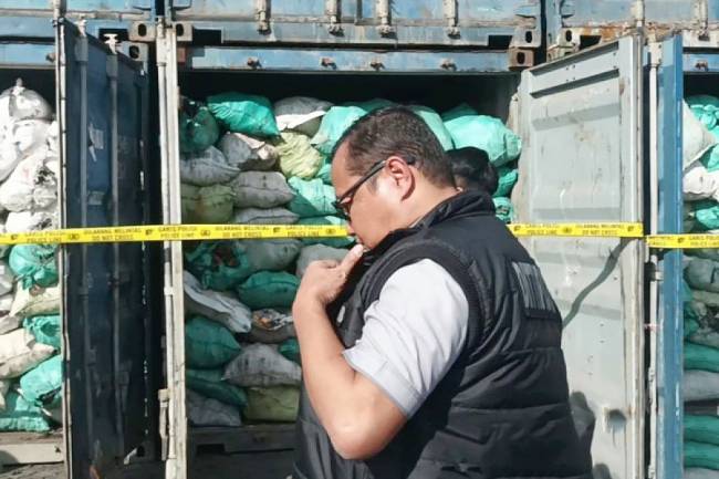 Petugas memasang garis polisi pada sejumlah kontainer berisi batu bara hasil pertambangan ilegal asal kawasan konservasi Ibu Kota Nusantara di sebuah Depo kawasan Pelabuhan Tanjung Perak Surabaya, Kamis (17/7/2025). (ANTARA/Hanif Nashrullah