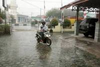 Warga melintasi jalan protokol saat hujan menguyur Kota Palangka Raya. (ANTARA/Rendhik Andika)