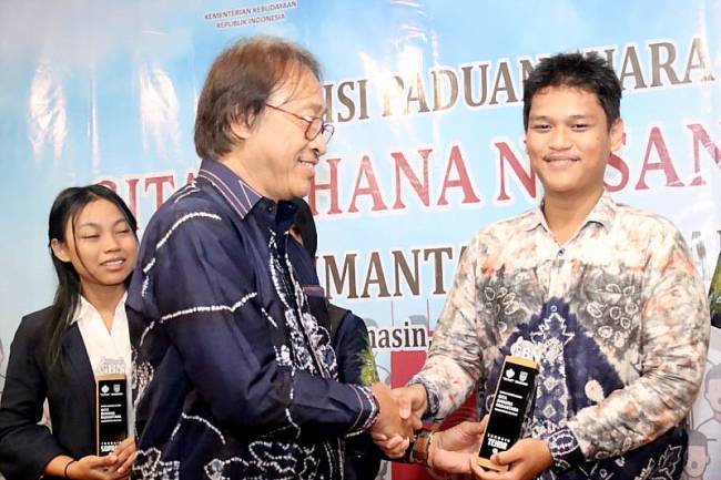 Dewan juri nasional Purwa Tjaraka (kiri depan) menyerahkan piagam kepada salah satu peserta audisi paduan suara Gita Bahana Nusantara (GBN) asal Kalimantan Selatan (Kalsel) yang lolos mengikuti audisi tingkat nasional di Banjarmasin, Kamis (10/7/2025). (ANTARA/HO-Medcen Kalsel)