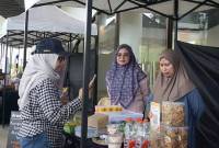 Deputi Bidang Lingkungan Hidup dan SDA Otorita IKN Myrna Asnawati Safitri sedang melakukan transaksi nontunai di food festival kuliner di Sentra Masa IKN. (ANTARA/Aditya Nugroho)