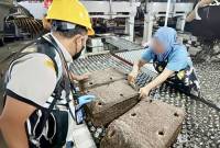 Petugas karantina memeriksa sampel karet lempengan sebelum diekspor ke China saat berada di gudang penyimpanan di Banjarmasin, Kalimantan Selatan, Senin (21/7/2025). (ANTARA/HO-Karantina Kalsel)