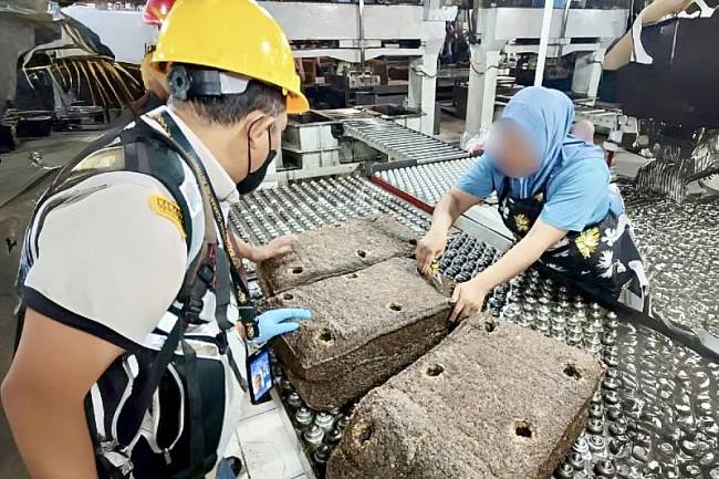Petugas karantina memeriksa sampel karet lempengan sebelum diekspor ke China saat berada di gudang penyimpanan di Banjarmasin, Kalimantan Selatan, Senin (21/7/2025). (ANTARA/HO-Karantina Kalsel)