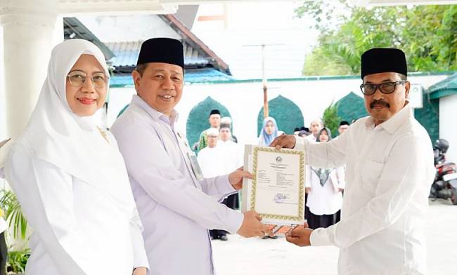 Kepala Kanwil Kemenag Kalsel H Muhammad Tambrin didampingi istri saat menyerahkan sertifikat atau SK izin operasional madrasah tahun 2025, di Banjarmasin, Senin (14/7/2025). (ANTARA/HO-Kemenag Kalsel)